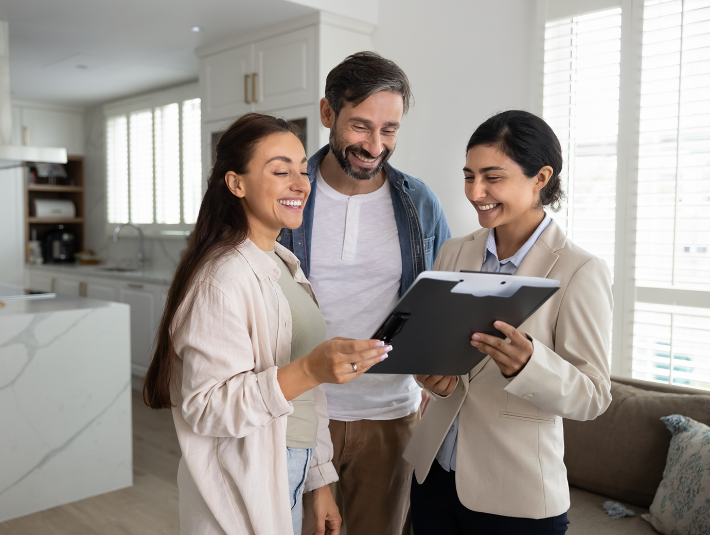 Happy couple reviewing documents with agent